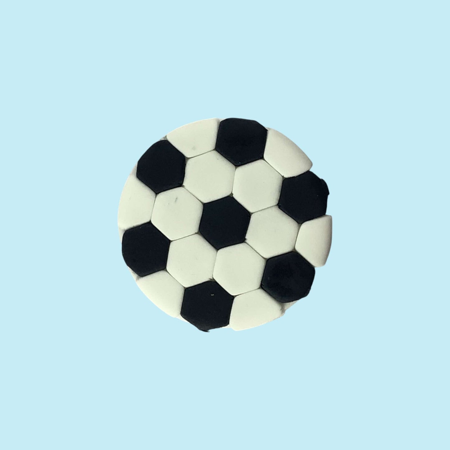 Soccer ball-shaped cupcake topper on a light blue background