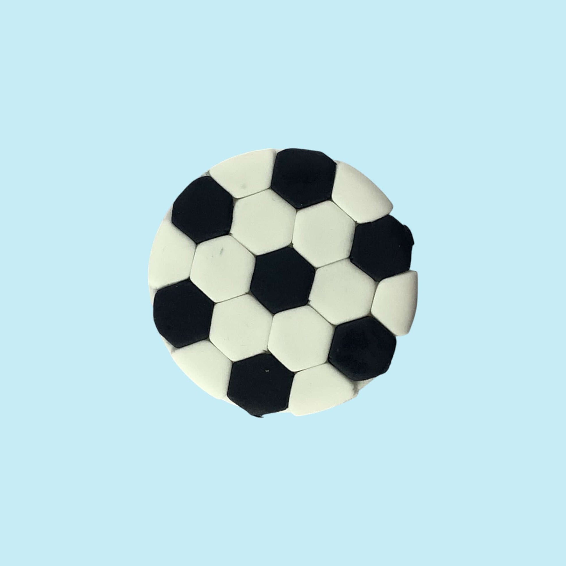 Soccer ball-shaped cupcake topper on a light blue background