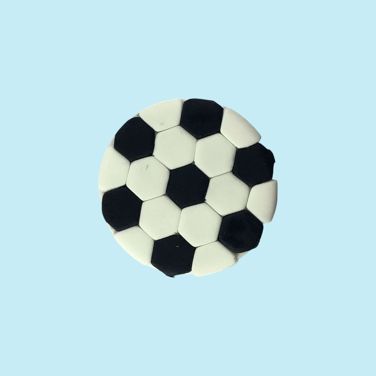 Soccer ball-shaped cupcake topper on a light blue background