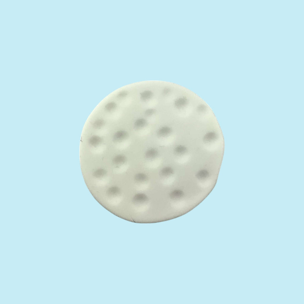 Round white golf ball cupcake topper on a light blue background 