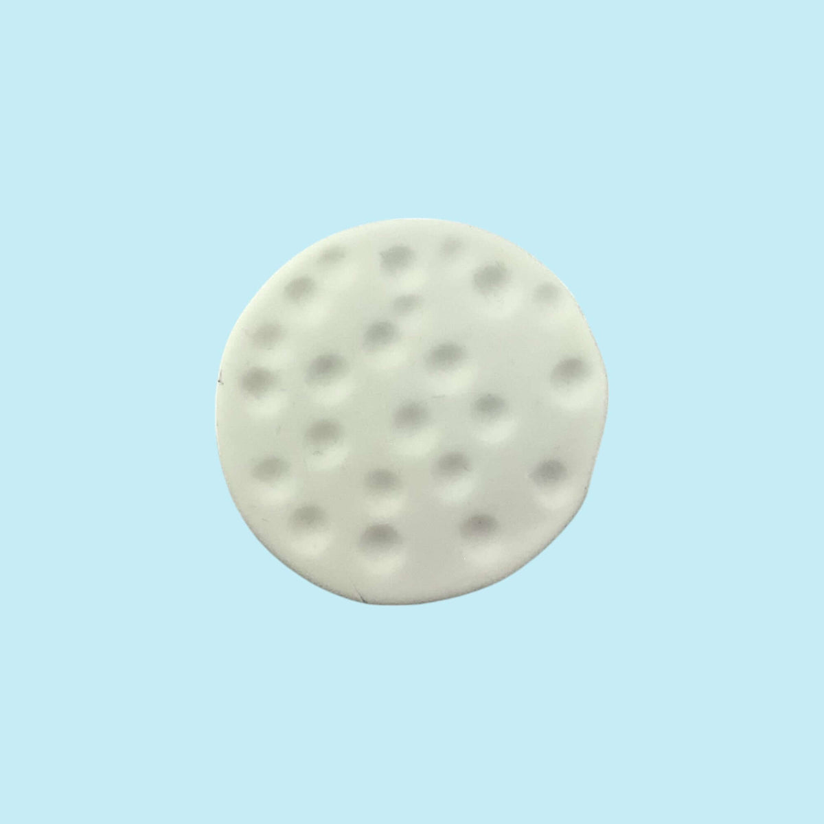 Round white golf ball cupcake topper on a light blue background 