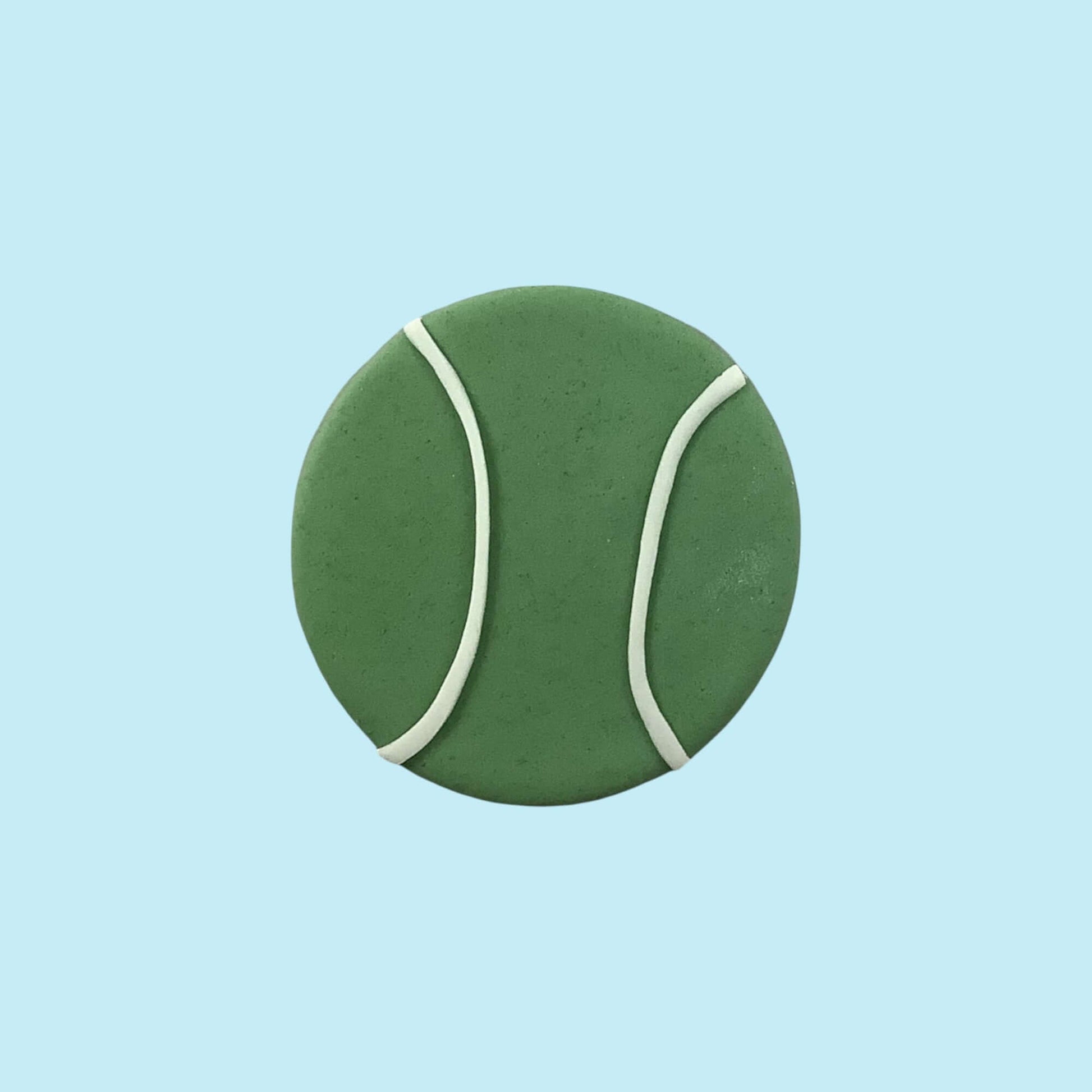 Green tennis ball with white seams on a light blue background